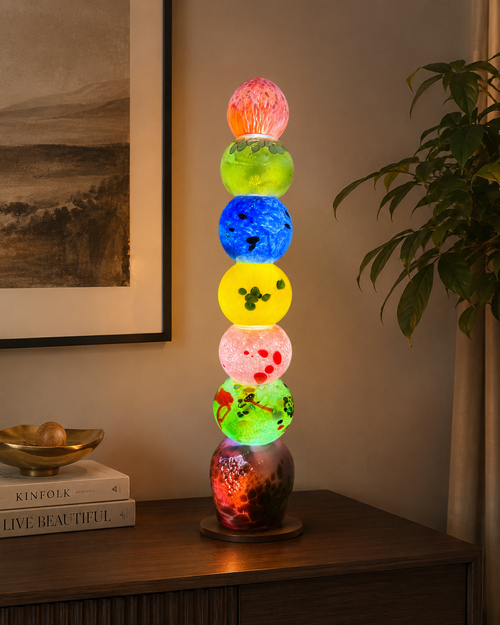 Colorful 26 inch handblown glass light tower displayed as illuminated art lighting in a home setting
