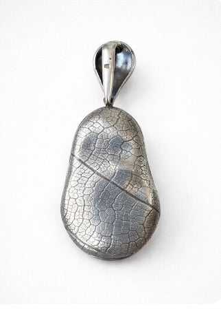 Handcrafted sterling silver amber pendent with leaf-inspired textured detailing and natural inclusions.