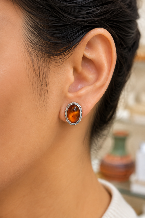 Baltic amber oval sterling silver stud earring shown on ear