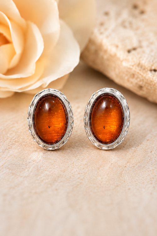 Oval Baltic amber stud earrings set in sterling silver