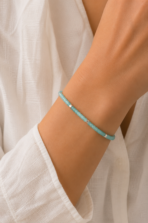 Model wearing a handcrafted Amazonite bracelet with natural 2.5 mm Amazonite gemstones and matte sterling silver cube beads, elegant minimalist jewelry for women.