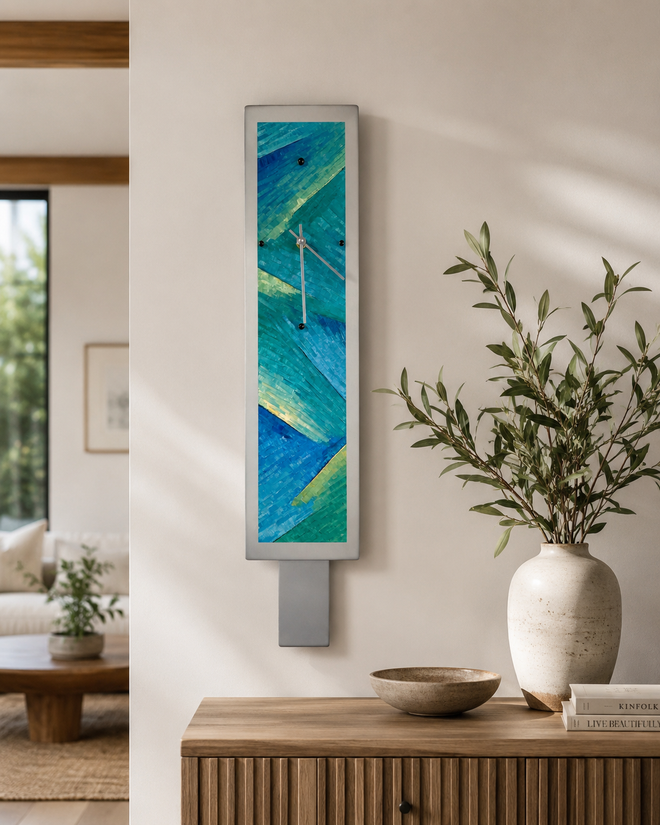 Hand-painted aluminum pendulum wall clock with brushed silver frame and aqua, teal, seafoam, and blue abstract design, 29 inches long by 6 inches wide.