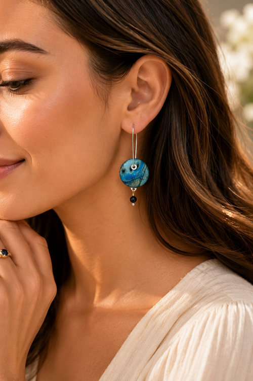Blue sterling silver earrings shown on model ear for size reference.