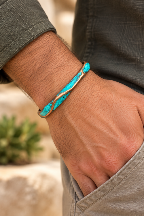 Blue-green patina copper cuff bracelet shown on a man's wrist, featuring a slim sculptural handmade design.