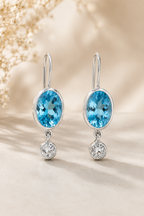 Handmade Blue Topaz and White Topaz sterling silver drop earrings featuring genuine oval Blue Topaz gemstones and sparkling White Topaz accents.
