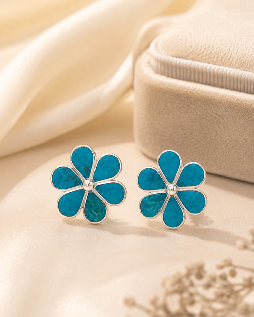 Chrysocolla flower stud earrings displayed in a luxury jewelry setting with polished sterling silver