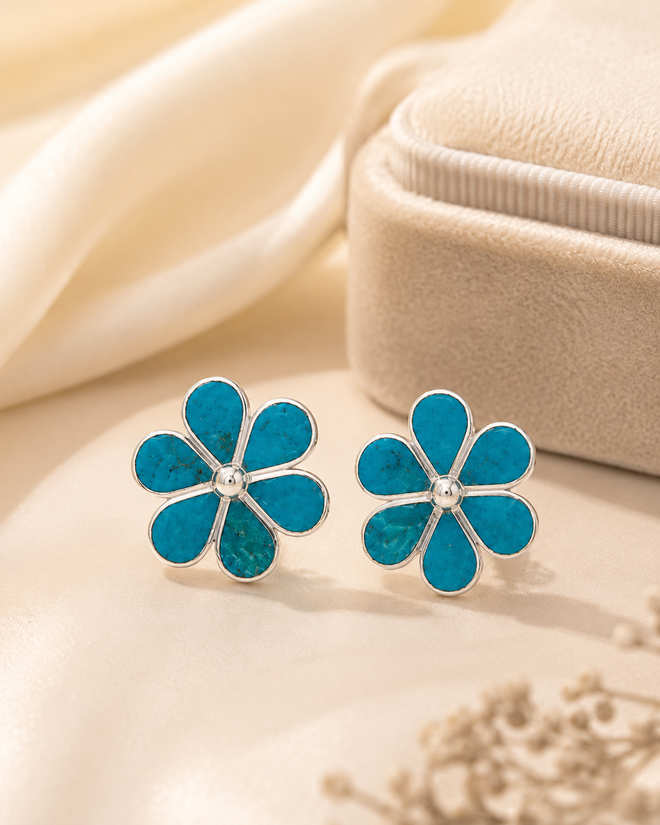 Chrysocolla flower stud earrings displayed in a luxury jewelry setting with polished sterling silver