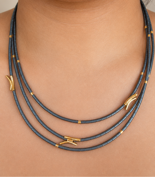 Close-up view of layered hematite necklace showing gold accent beads and contemporary gold elements