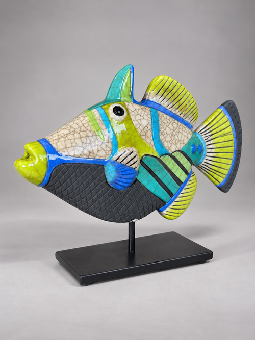 Side view of colorful Picasso ceramic fish with textured black details, vibrant striped fins and distinctive crackle-glaze finish.