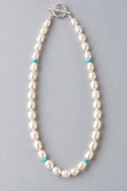 17-inch handmade necklace featuring cream oval freshwater pearls, four Kingman turquoise accent beads and sterling silver toggle clasp.