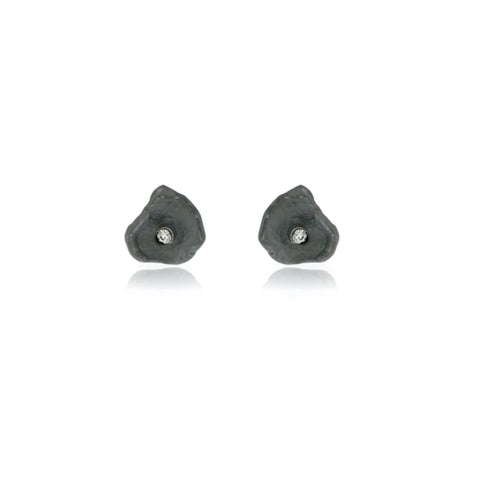 Close-up of handcrafted oxidized sterling silver petal earrings with brilliant cubic zirconia, boutique designer jewelry featuring an organic sculptural floral design.