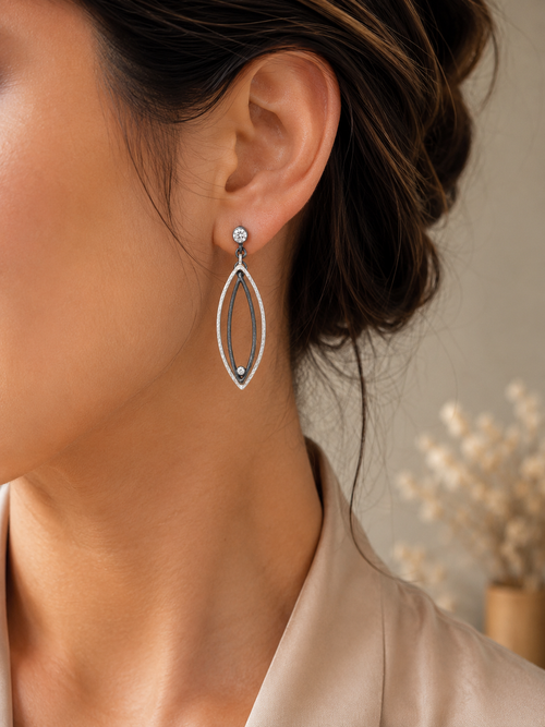 Handcrafted oxidized sterling silver earrings featuring marquise shapes and sparkling cubic zirconia accents displayed in a luxury jewelry setting.