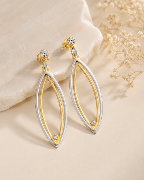 Two-tone sterling silver and gold vermeil earrings with cubic zirconia shown on ear for size reference, artisan jewelry from Jerome Arizona.