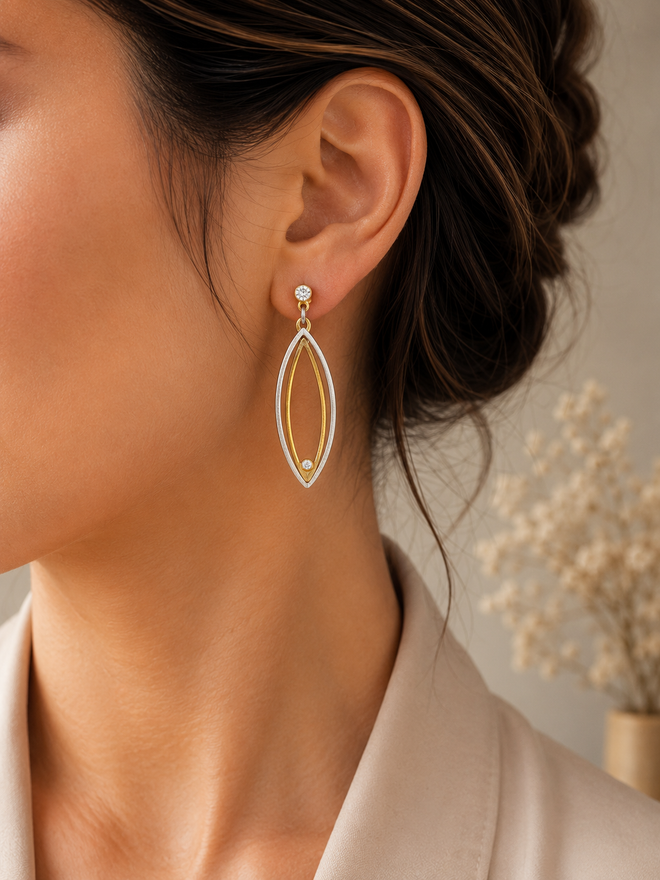 Handcrafted two-tone sterling silver earrings with cubic zirconia displayed in an elegant jewelry setting at Raku Gallery, a fine art and jewelry gallery in Jerome Arizona.