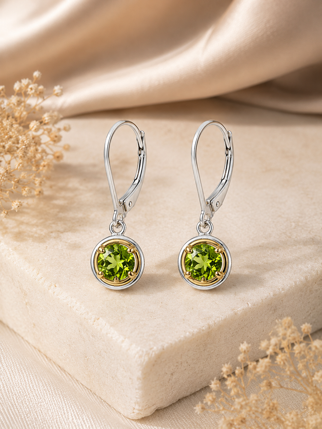 Elegant sterling silver drop earrings featuring vibrant round natural peridot gemstones framed with warm gold accents and secure leverback ear wires.