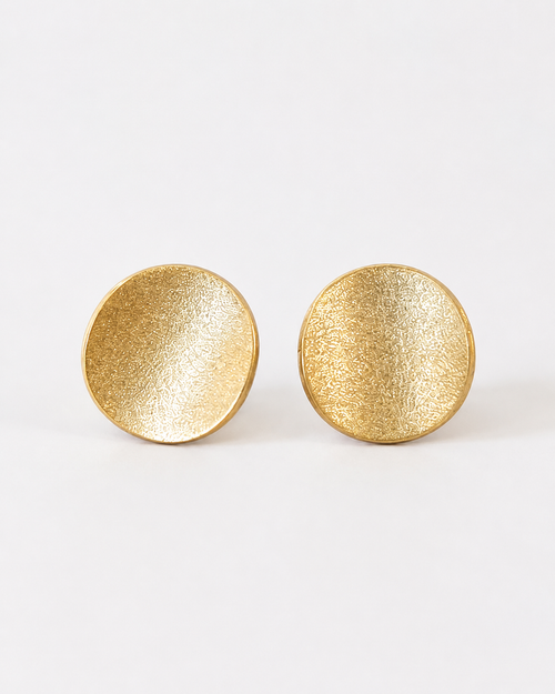 Gold plated sterling silver disc stud earrings displayed in a luxury setting