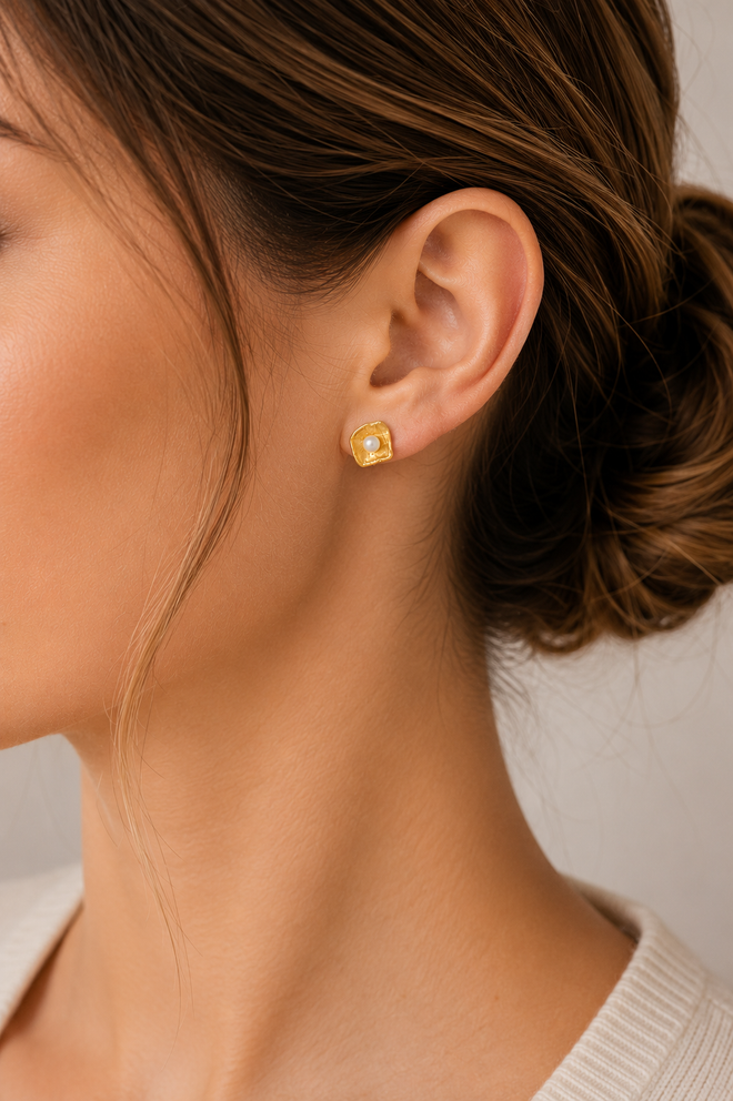 Woman wearing handmade gold vermeil shell stud earrings with genuine freshwater pearls, elegant minimalist artisan jewelry for everyday luxury and special occasions.
