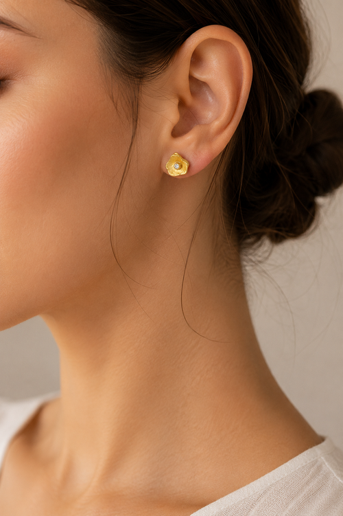 Woman wearing handmade gold vermeil petal stud earrings with cubic zirconia, minimalist sterling silver designer jewelry perfect for everyday elegance.