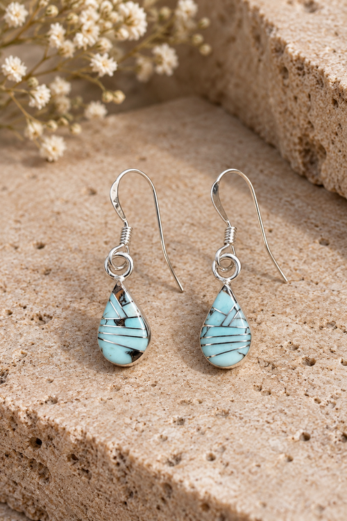 Golden Hills turquoise drop earrings in sterling silver featuring pale blue gemstones, geometric silver inlay and delicate French hooks.