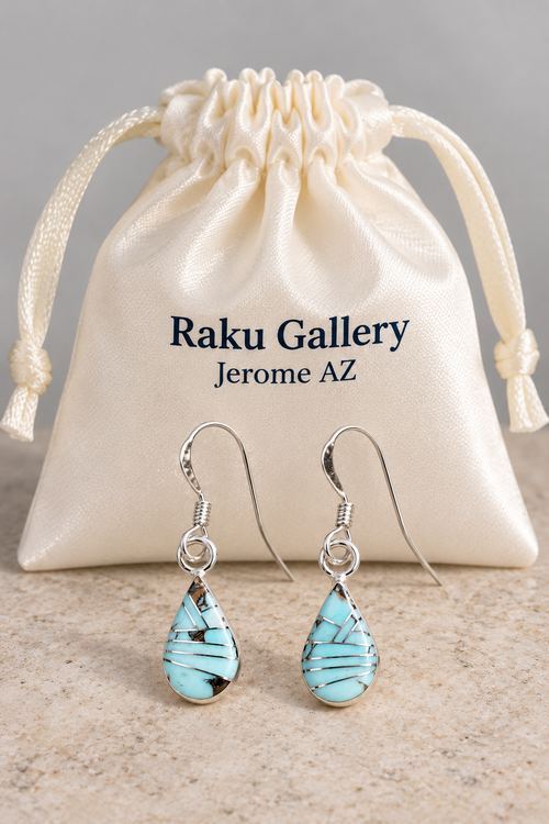 Pale blue Golden Hills turquoise inlay earrings with sterling silver French hooks displayed in front of a Raku Gallery satin jewelry pouch.