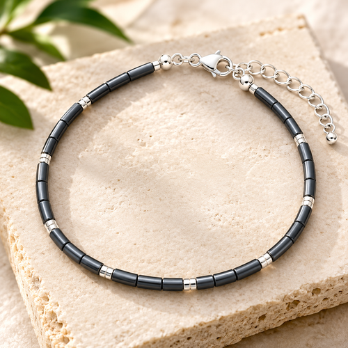Handcrafted graphite hematite cylinder bracelet featuring 2x4 mm hematite beads, polished sterling silver spacer beads, and an adjustable sterling silver extension chain.