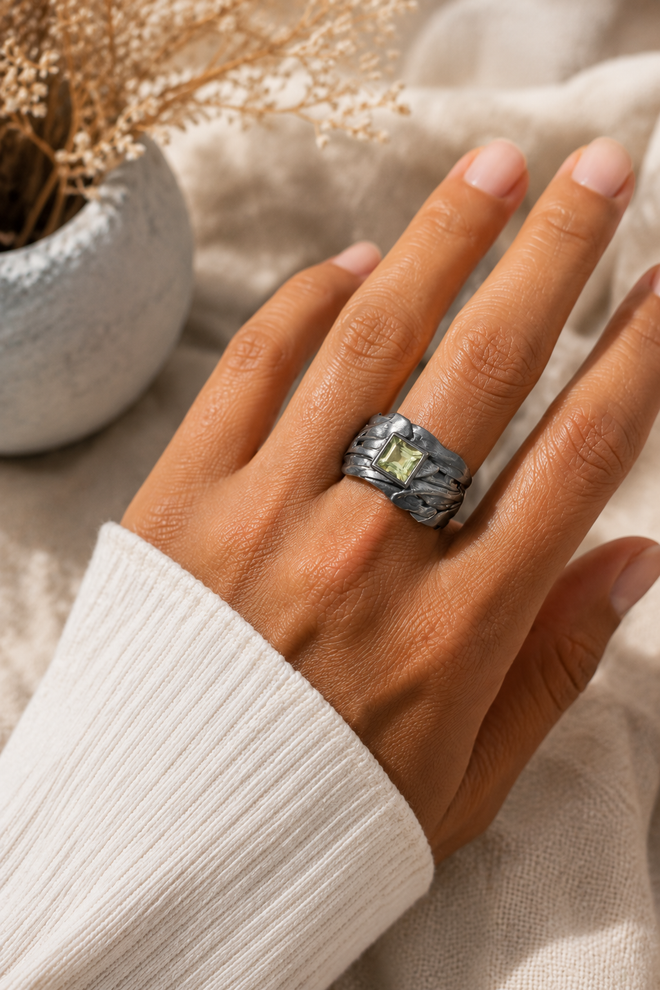 One-of-a-kind handmade Green Amethyst ring worn on hand featuring a 4mm square Green Amethyst in oxidized sterling silver with a wide sculptural artisan band.