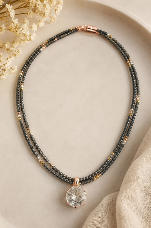 Handmade 18-inch grey hematite beaded necklace with mixed gold, silver and rose gold accent beads and a crystal pendant.