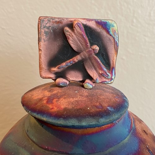 Handmade metallic Raku pottery vessel with dragonfly lid, signed by the artist and finished with unique natural firing patterns