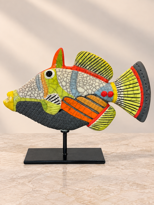 Handmade orange and lime green Raku ceramic fish sculpture on black stand with distinctive crackle glaze
