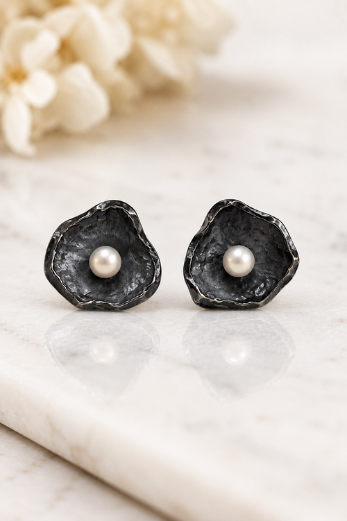 Handmade oxidized sterling silver petal stud earrings with genuine freshwater pearls featuring a modern organic floral design, artisan handcrafted jewelry.