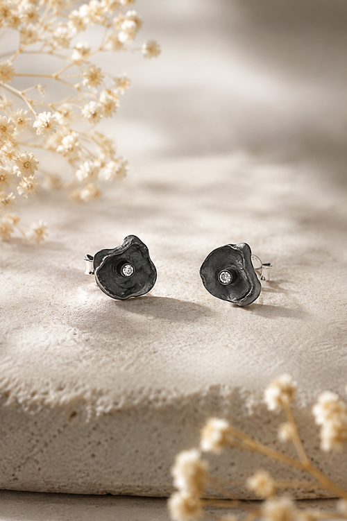 Handmade oxidized sterling silver petal stud earrings featuring sparkling cubic zirconia, contemporary artisan jewelry for women with an elegant organic floral design.