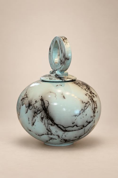 Side View - Handmade pale blue turquoise horsehair raku pottery vessel with rounded form and natural black horsehair markings