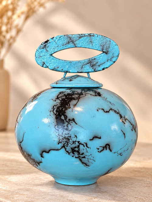 Handmade pale blue turquoise raku ceramic vessel with horsehair markings and rounded lidded form