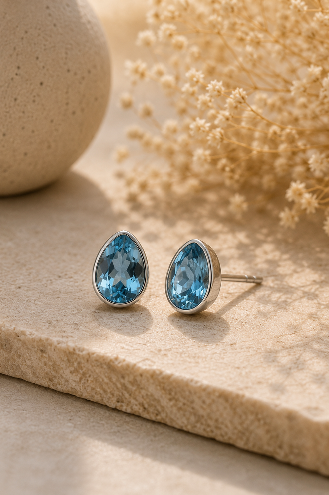 Handmade pear-shaped Blue Topaz stud earrings in sterling silver featuring brilliant faceted natural Blue Topaz gemstones in elegant bezel settings.