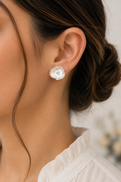 Model wearing handmade sterling silver petal stud earrings with brilliant cubic zirconia. Elegant artisan floral earrings designed for everyday luxury and timeless style.