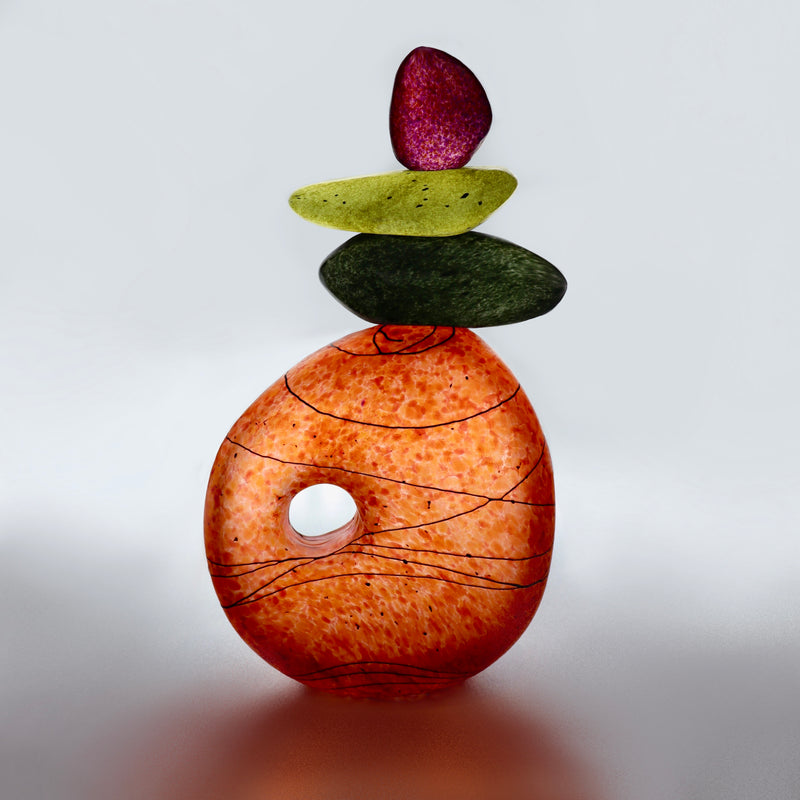 A sculptural composition of organically shaped stones delicately stacked on a handcrafted, speckled ceramic sphere—blending natural balance with modern minimalism