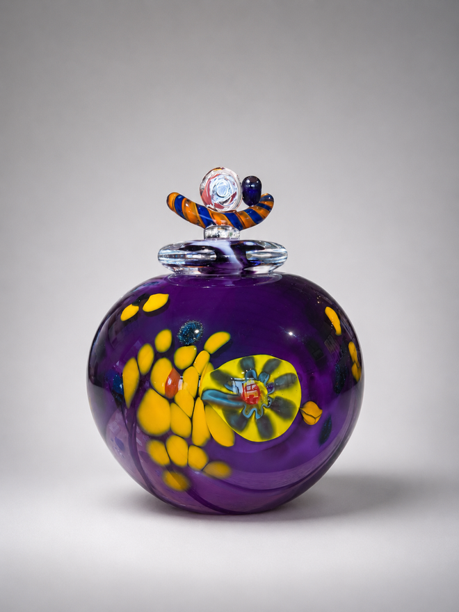 Side view of purple Jon Oaks handblown glass vessel with fitted lid