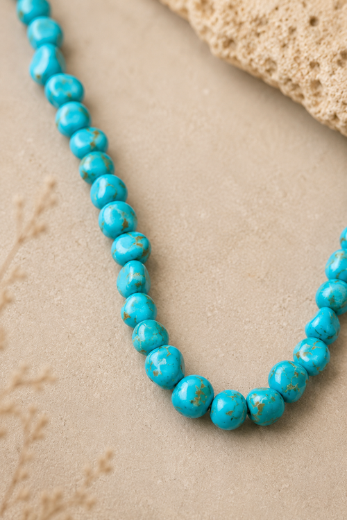 Close-up of genuine Kingman turquoise necklace beads showing irregular shapes and natural brown matrix