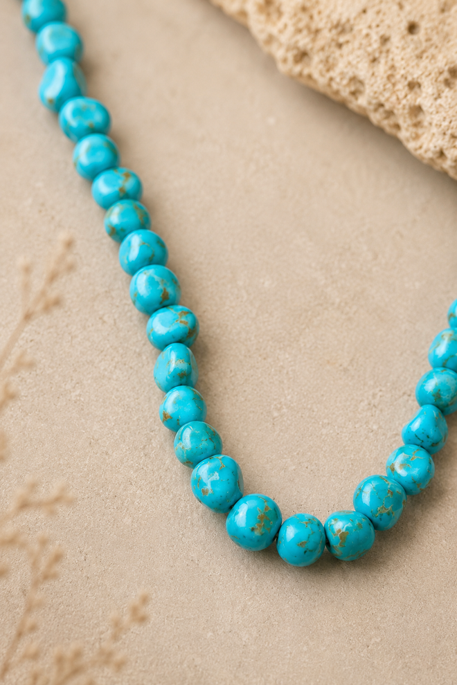 Close-up of genuine Kingman turquoise necklace beads showing irregular shapes and natural brown matrix