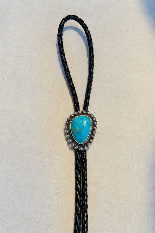 Kingman turquoise sterling silver bolo tie by S. Skeet with detailed silverwork and natural turquoise matrix