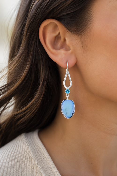 Model wearing one-of-a-kind Lavender Turquoise and Teal Apatite sterling silver earrings handcrafted with natural gemstones and artisan detail.
