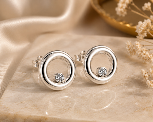 Luxury handcrafted sterling silver circle stud earrings with brilliant white cubic zirconia displayed in an elegant lifestyle setting, contemporary fine jewelry for women.