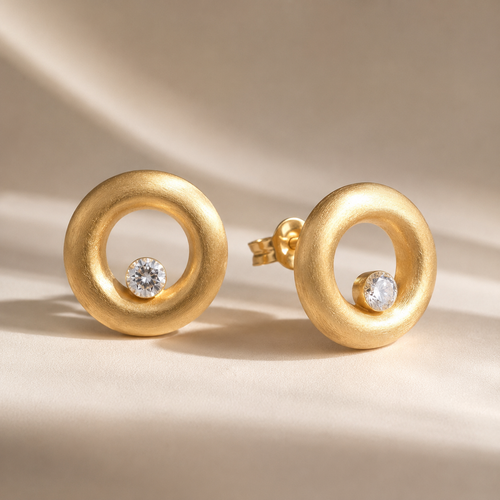 Handcrafted matte gold vermeil open circle stud earrings featuring brilliant 4 mm white cubic zirconia and a brushed satin finish in sterling silver.