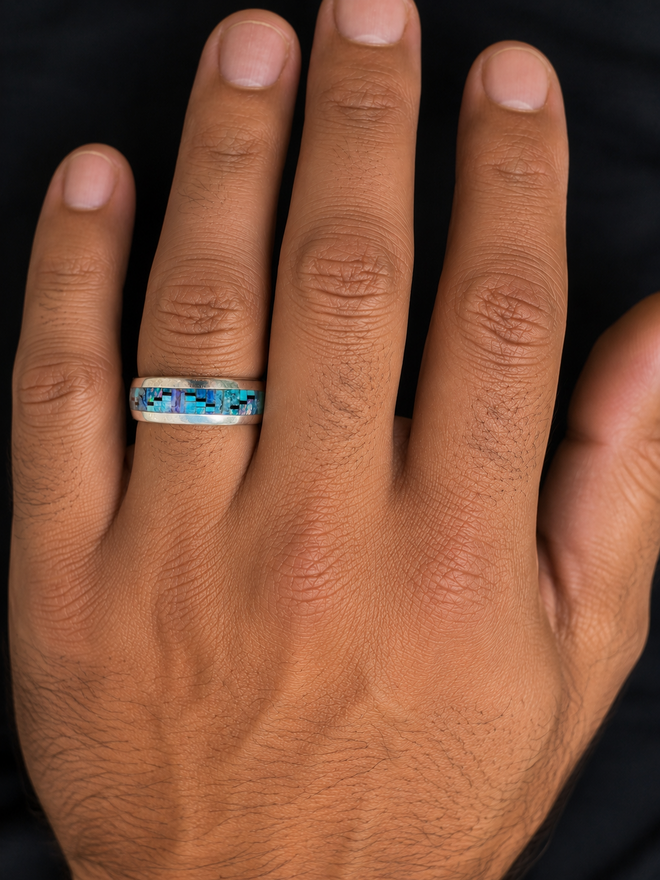 Close-up of a Native American sterling silver men’s ring with colorful geometric stone inlay.