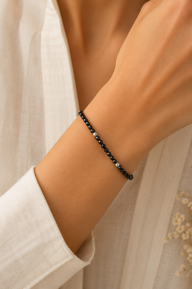 Model wearing a handcrafted black spinel bracelet with matte sterling silver beads, elegant minimalist gemstone jewelry for everyday wear.