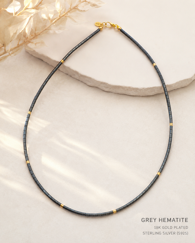 Minimalist grey hematite necklace with gold plated sterling silver accents shown as elegant everyday jewelry.