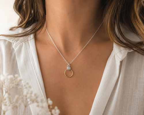 Lifestyle image of a sterling silver and gold-filled circle pendant necklace with cubic zirconia, elegant everyday jewelry for women