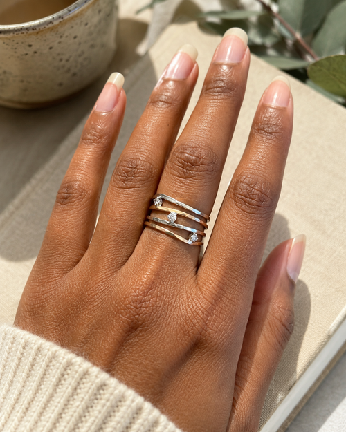 Mixed metal sterling silver and gold wave ring shown on hand