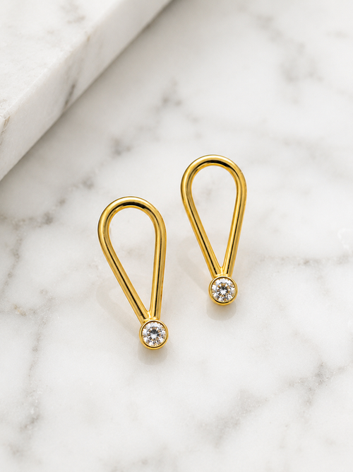 Modern gold loop drop earrings featuring cubic zirconia stones