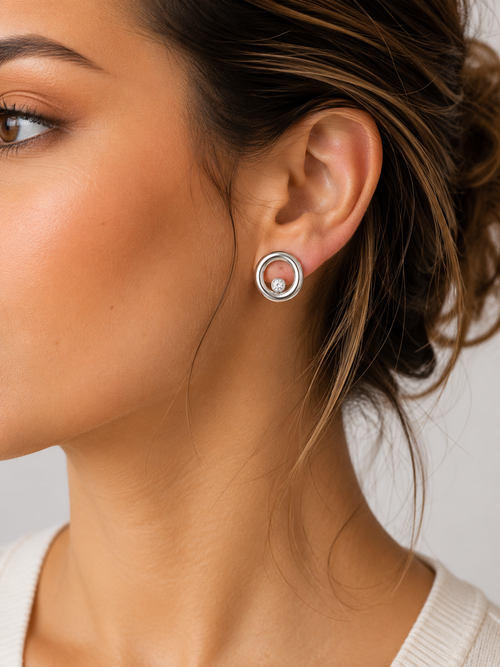 Model wearing polished sterling silver open circle stud earrings with sparkling 4 mm cubic zirconia, contemporary handcrafted jewelry for everyday and special occasions.